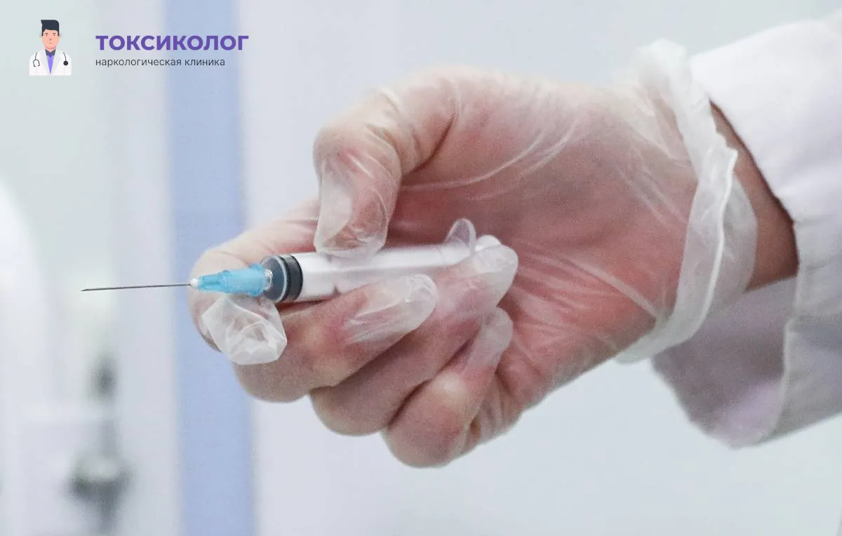 Врач в медицинских перчатках демонстрирует упаковку и флакон с препаратом для проведения процедуры кодирования Налтрексоном.